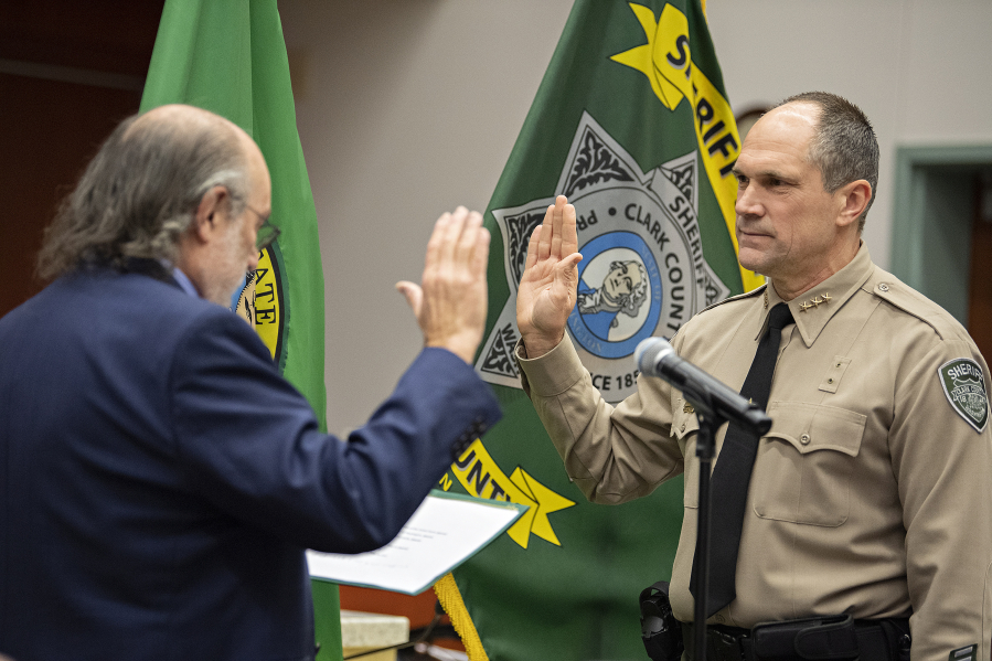 Retired judge Rich Melnick, left, administers the oath of office to new Sheriff John Horch Thursday at the Clark County Public Service Center. Melnick recalled watching Horch's career grow over the course of their 30-year friendship.