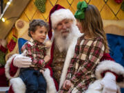 Santa Claus, center, listens to what Luciana, 6, right, and Roman Sereno, 4, both of Battle Ground, want for Christmas at the Vancouver Mall. Legos have been a popular ask from children this year, along with Barbies, Nintendo Switches and the occasional yo-yo.