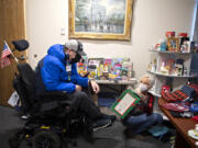 CDM Caregiving Services client Aaron Roth looks over the assortment of presents in the Christmas store with the help of volunteer Diana Schafer. The Christmas store is open for two weeks each December for CDM patients to do their Christmas shopping for free.