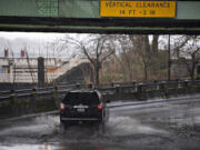 A motorist navigates a pool of standing water underneath the Interstate Bridge on Tuesday morning, Dec. 27, 2022.