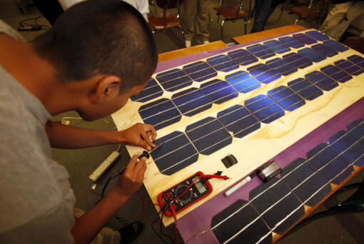 A worker making solar panels in a 2011file image.