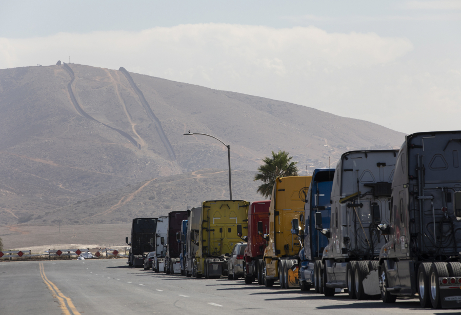 A line of semi-trailer trucks line Enrico Fermi Place, a street minutes away from the Otay Mesa Port of Entry, on Thursday, Sept. 23, 2021, in Otay Mesa, California.
