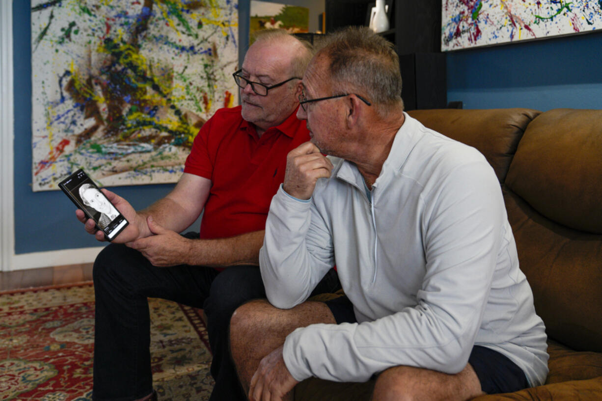 Peter Shatner and his half brother, Darren Freedman, look at a photo of their late father on Shatner's phone. DNA testing recently connected Shatner to his biological father and his half siblings after decades of believing his father was actor William Shatner.
