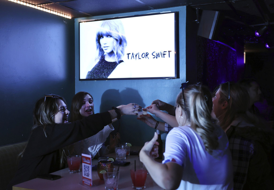 Taylor Swift fans celebrate during a listening party for her "Midnights" album at Woodie's Flat on Oct. 20 in Chicago.