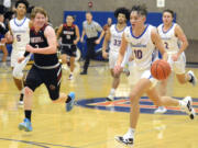 Ridgefield’s Colten Castro, right, races up the court in transition against Fort Vancouver on Wednesday, Dec. 7, 2022, at Ridgefield High School.