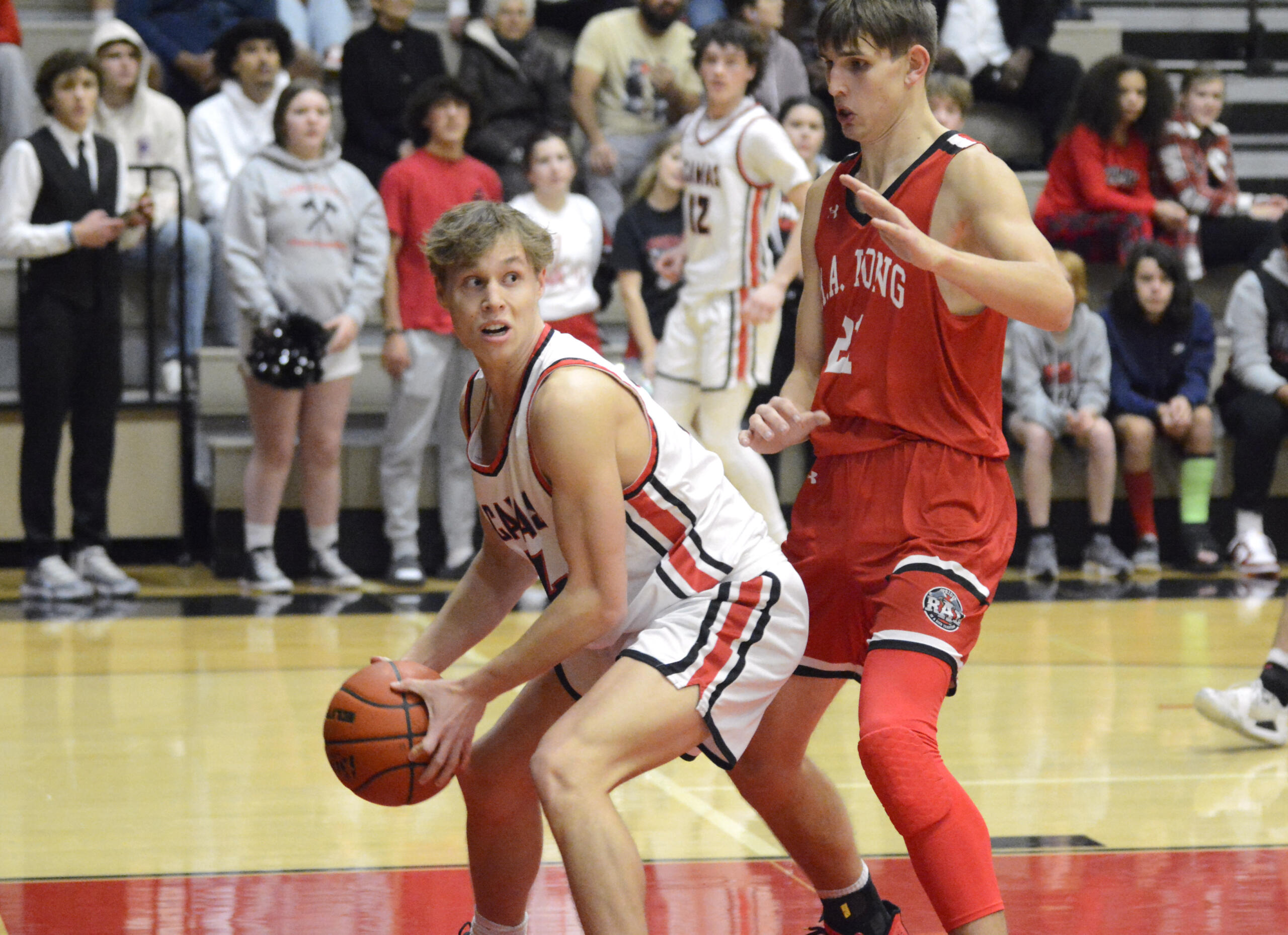 Camas senior center Josh Dabasinskas, left, looks to make a pass out of the post while being defended by R.A. Long’s Jaxson Cook in a non-league boys basketball game on Tuesday, Dec. 13, 2022, at Camas High School.