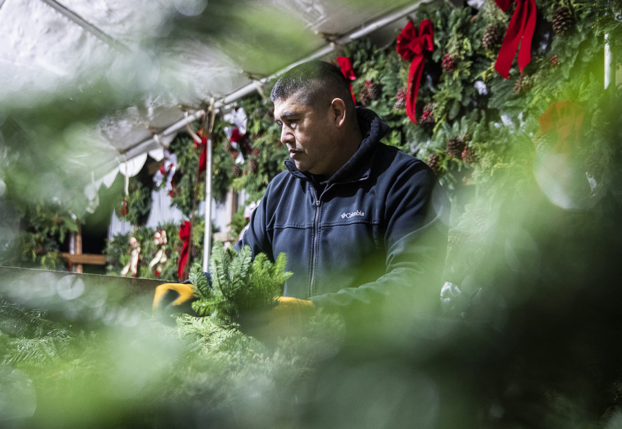 Franco Montano works on putting together a wreath at his workshop on Dec. 5 in Snohomish.