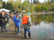 Mike Golob, the president of the Southwest Washington Anglers, helps his son land a trout during the Klineline Kids fishing derby while a volunteer with the club waits to net the fish. This huge event has always depended on sportsman's clubs' volunteers, which are in short supply post-COVID.