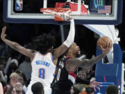 Portland Trail Blazers guard Damian Lillard (0) shoots in front of Oklahoma City Thunder forward Jalen Williams (8) in the second half of an NBA basketball game Monday, Dec. 19, 2022, in Oklahoma City.