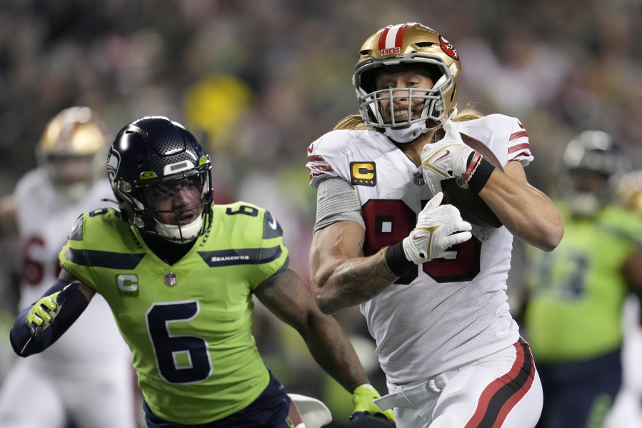 San Francisco 49ers tight end George Kittle, right, runs toward the end zone to score past Seattle Seahawks safety Quandre Diggs (6) during the first half of an NFL football game in Seattle, Thursday, Dec. 15, 2022.