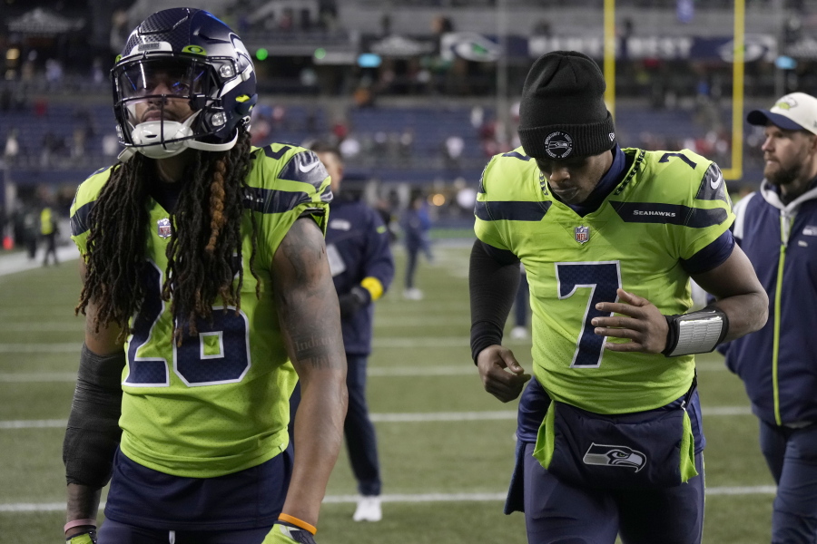 Seattle Seahawks safety Ryan Neal, left, and quarterback Geno Smith walk off the field after an NFL football game against the San Francisco 49ers in Seattle, Thursday, Dec. 15, 2022.