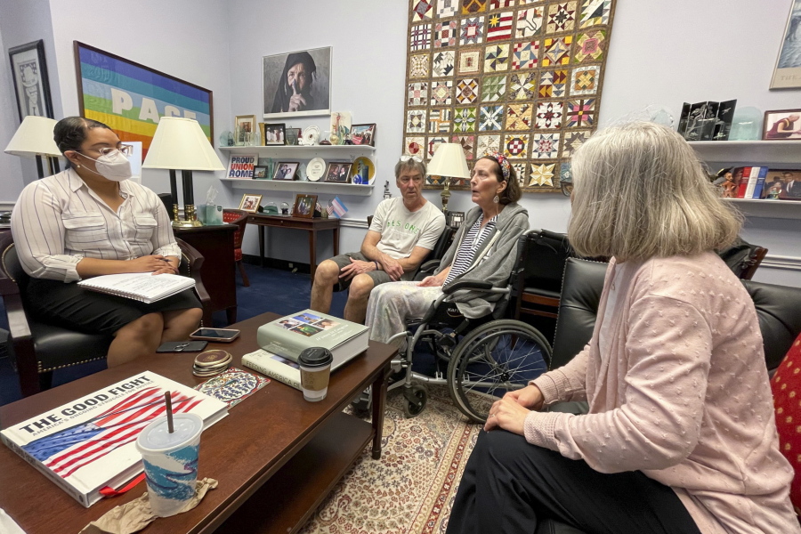 In this photo provided by Becky Mourey, Becky Mourey, center, and her husband Jim, left, meet with representatives for Illinois Rep. Jan Schakowsky at her offices on Capitol Hill, Washington DC in May 2022. Mourey and other ALS patients spent more than two years advocating for the approval of the new drug, Relyvrio, a treatment for ALS. Patients say they are now facing insurance and financial hurdles to access the drug, which costs $158,000.
