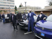 Washington Gov. Jay Inslee, second from right, poses for a photo, Monday, Dec. 13, 2021, with car dealership representatives who drive electric vehicles to a news conference in Olympia, Wash. Inslee announced several climate-related proposals for the 2022 legislative session, including a plan to offer rebates on the purchase of new and used electric vehicles for qualified buyers. (AP Photo/Ted S.