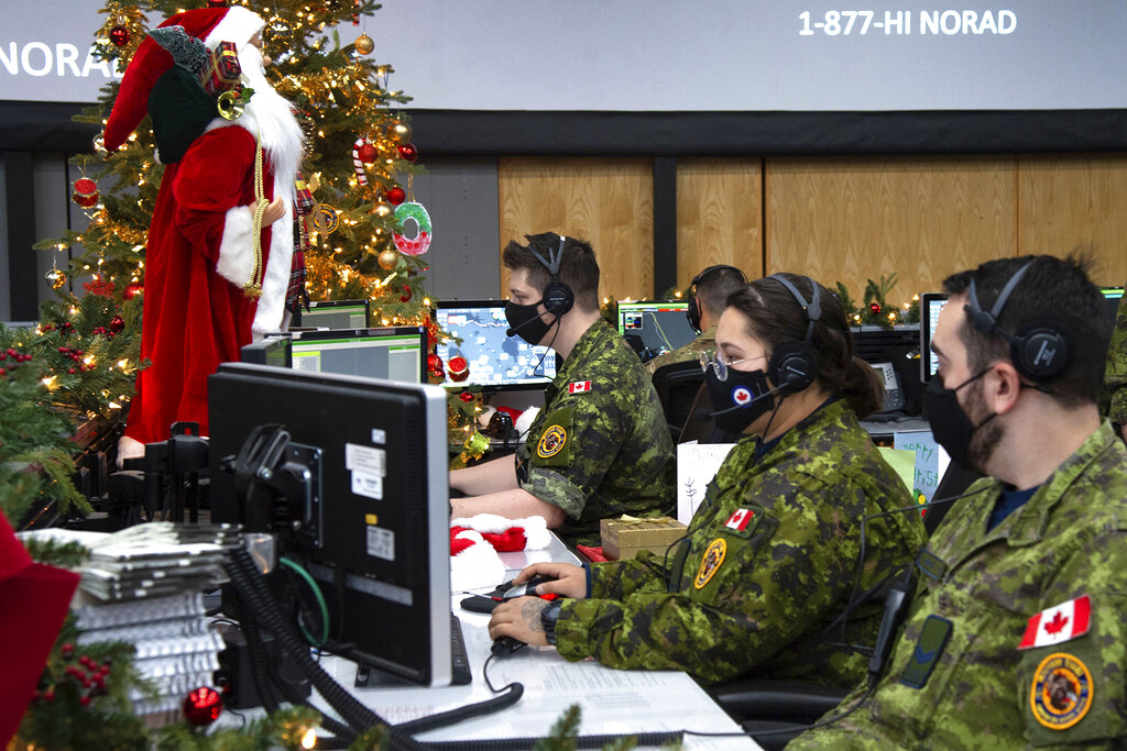 In this photo provided by the North American Aerospace Defense Command, 22 Wing members are seen showing how they track Santa on his sleigh on Christmas eve during a media preview at the Canadian Forces Base in North Bay on Dec. 9, 2021. In a Christmas Eve tradition going on its 66th year, a wildly popular program run by the U.S. and Canadian militaries is providing real-time updates on Santa's progress around the globe -- and fielding calls from children who want to know St. Nick's exact whereabouts.
