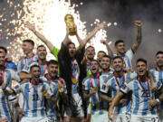 Argentina's Lionel Messi lifts the trophy after winning the World Cup final soccer match between Argentina and France at the Lusail Stadium in Lusail, Qatar, Sunday, Dec. 18, 2022. Argentina won 4-2 in a penalty shootout after the match ended tied 3-3.