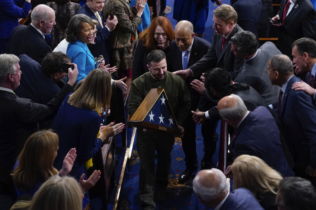 Ukrainian President Volodymyr Zelenskyy holds an American flag that was gifted to him by House Speaker Nancy Pelosi of Calif., as he leaves after addressing a joint meeting of Congress on Capitol Hill in Washington, Wednesday, Dec. 21, 2022.