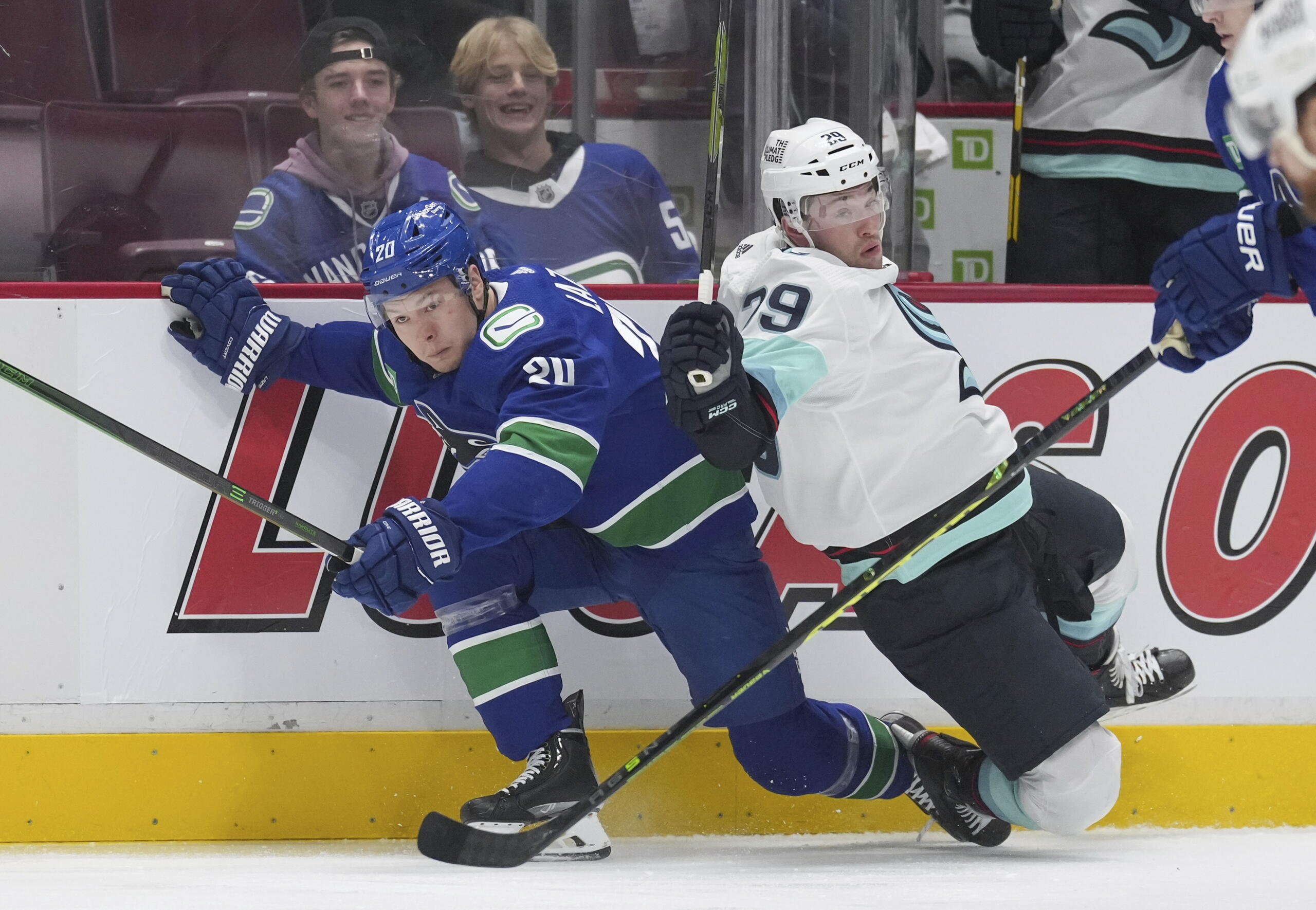 Vancouver Canucks' Curtis Lazar, left, and Seattle Kraken's Vince Dunn collide during the first period of an NHL hockey game Thursday, Dec. 22, 2022, in Vancouver, British Columbia.