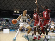 Hawaii guard Samuta Avea (32) tries to get past Washington State guard TJ Bamba (5) and center Adrame Diongue (15) during the second half of an NCAA college basketball game, Friday, Dec. 23, 2022, in Honolulu.