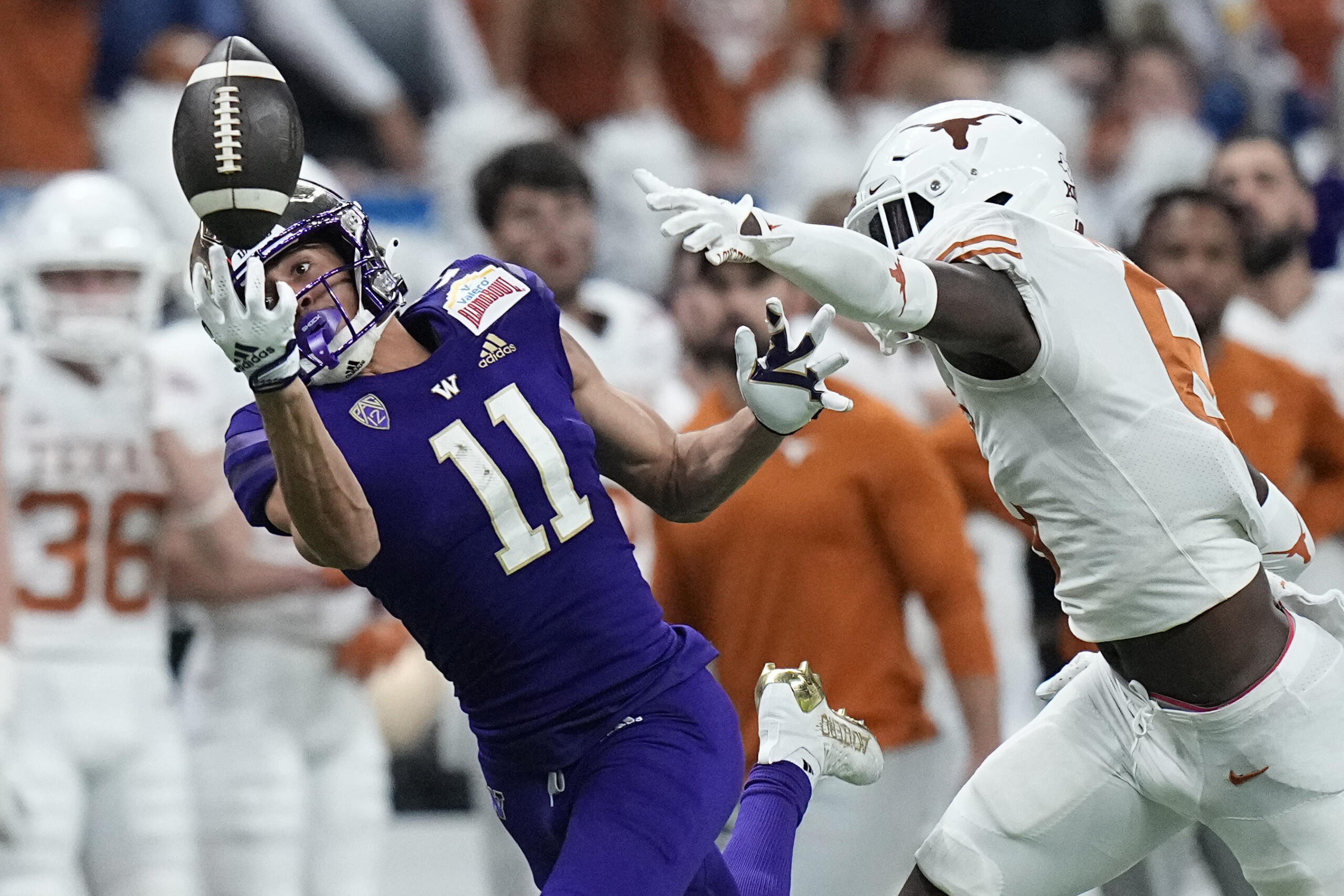 Washington wide receiver Jalen McMillan (11) fails to make a catch in front of Texas defensive back Ryan Watts (6) during the first half of the Alamo Bowl NCAA college football game in San Antonio, Thursday, Dec. 29, 2022.