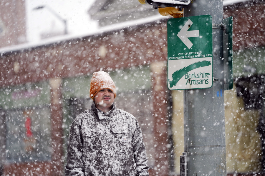 A man is covered in snow on Fenn Street in Pittsfield, Mass, Friday, Dec. 16, 2022.