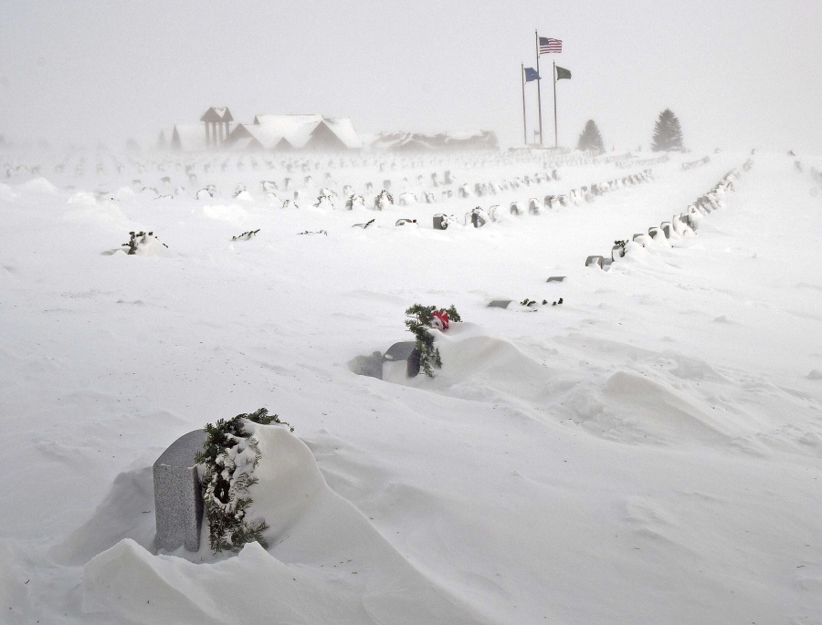 Rows of headstones at the North Dakota Veterans Cemetery are blanketed by drifting snow Thursday, Dec. 22, 2022, in Mandan, N.D.