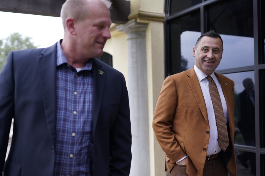 Texas head coach Steve Sarkisian, right, and Washington head coach Kalen DeBoer, left, head to a news conference for the Alamo Bowl NCAA college football game, Thursday, Dec. 8, 2022, in San Antonio. The teams will play in this year's Alamo Bowl.