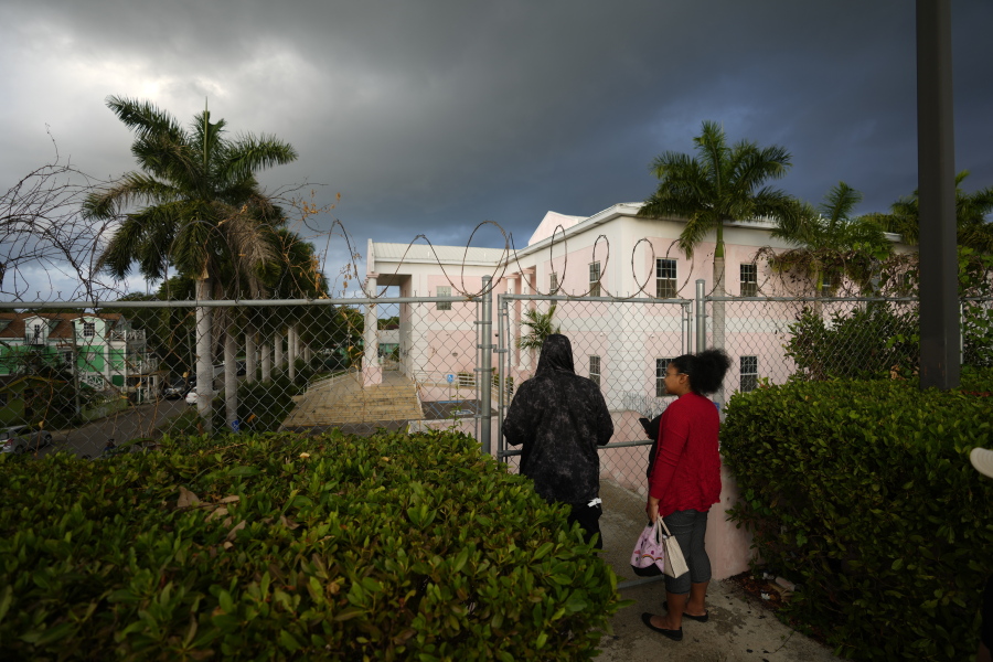 People wait outside the Magistrate Court building, where FTX founder Sam Bankman-Fried was expected to appear for an extradition hearing, in Nassau, Bahamas, early on Monday, Dec.