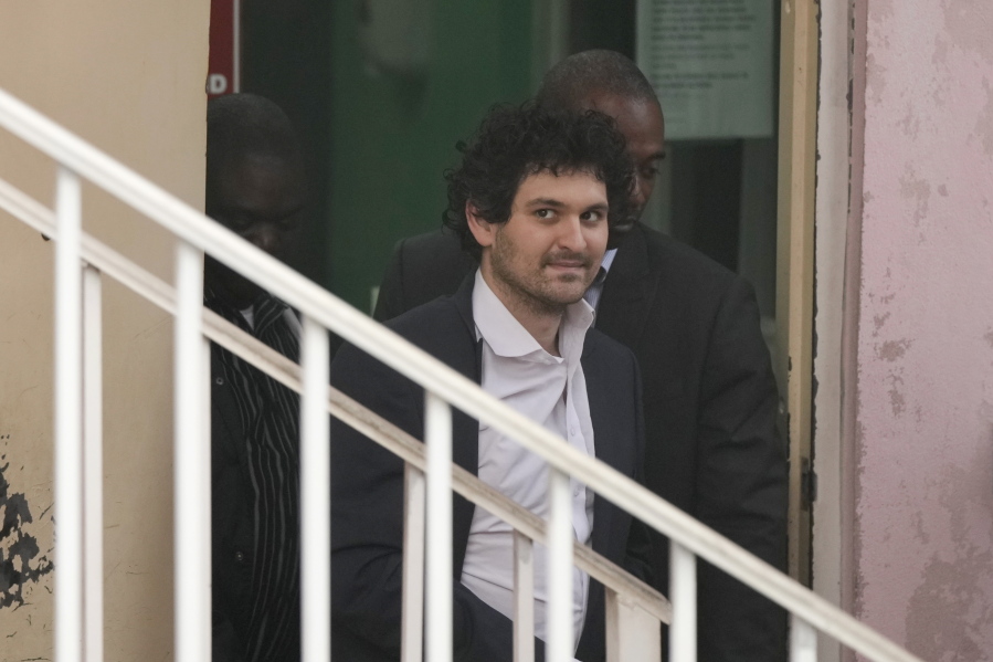 FTX founder Sam Bankman-Fried, is escorted from the Magistrate Court in Nassau, Bahamas, Wednesday, Dec. 21, 2022, after agreeing to be extradited to the U.S.