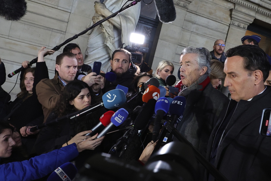 Lawyers for former European Parliament Vice-President Eva Kaili, Michalis Dimitrakopoulos, right, and Andre Risopoulos, second right, speak with the media at the courthouse in Brussels, Thursday, Dec. 22, 2022.