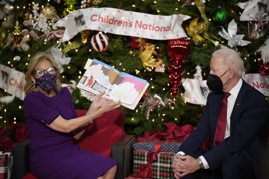 First lady Jill Biden, accompanied by President Joe Biden, reads "The Snowy Day" by Ezra Jack Keats at Children's National Hospital in Washington, Friday, Dec. 23, 2022.