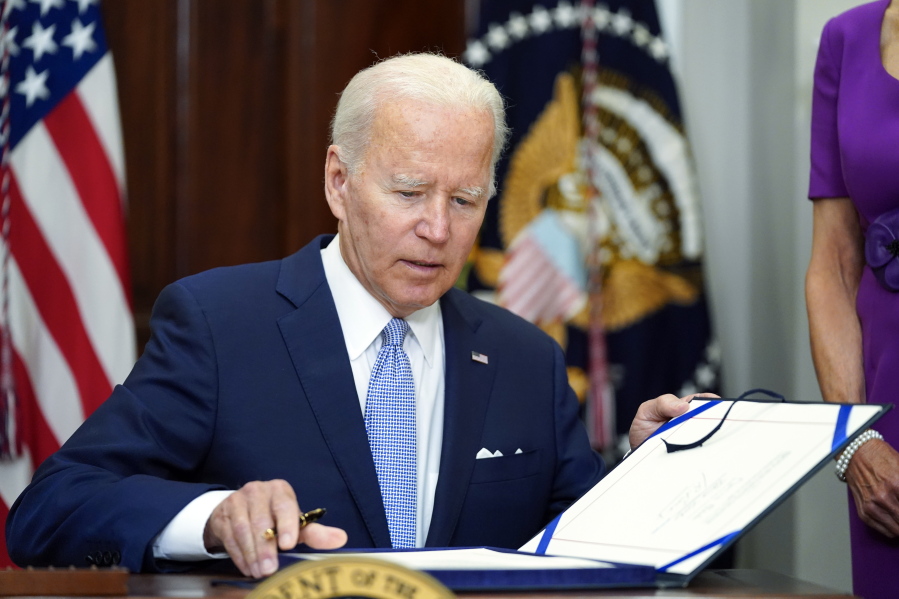 FILE - President Joe Biden signs into law S. 2938, the Bipartisan Safer Communities Act gun safety bill, in the Roosevelt Room of the White House in Washington, June 25, 2022.