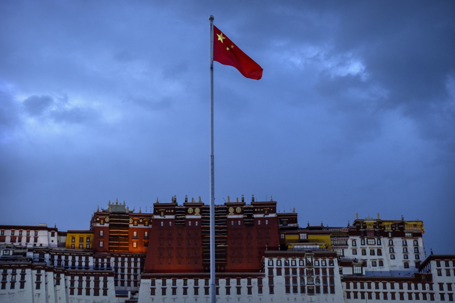 FILE - The Chinese flag flies at a plaza near the Potala Palace in Lhasa in western China's Tibet Autonomous Region, on June 1, 2021, as seen during a government organized visit for foreign journalists. China has sanctioned two U.S. individuals in retaliation for action taken by Washington over human rights abuses in Tibet, the government said Friday, Dec. 23, 2022, amid a continuing standoff between the sides over Beijing's treatment of religious and ethnic minorities.