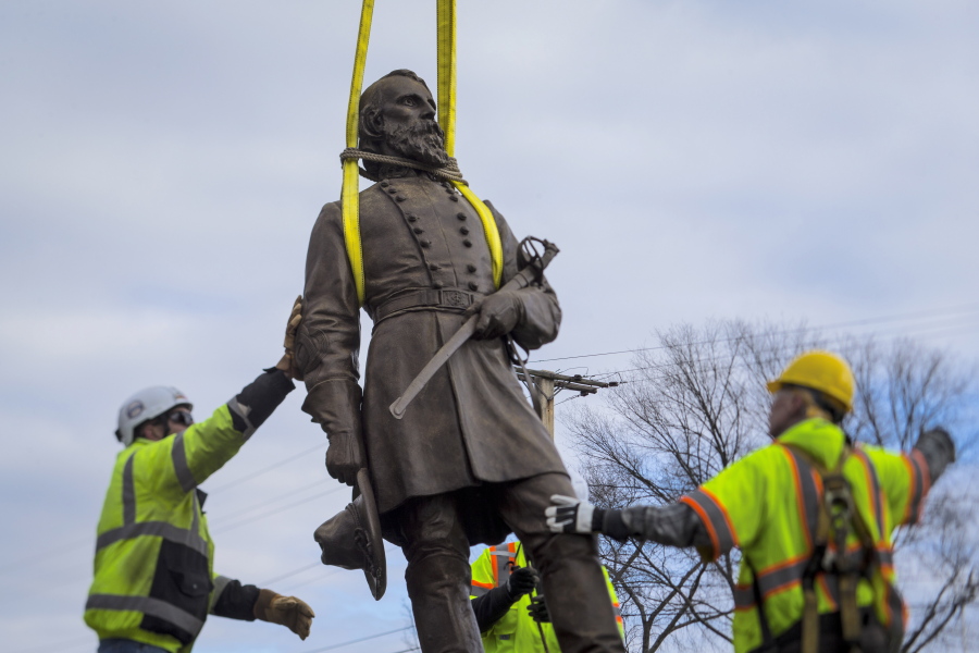 Workers begin to lay the bronze statue of Confederate General A.P. Hill onto a flatbed truck on Monday Dec. 12, 2022 in Richmond, Va. Workers are still planning to exhume the remains of General Hill which located inside the base of the statue. (AP Photo/John C.