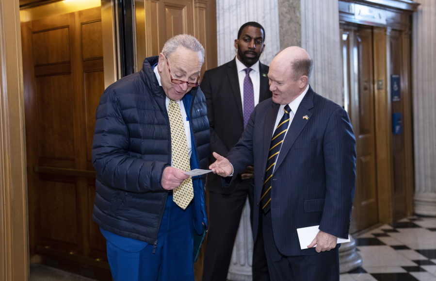 Senate Majority Leader Chuck Schumer, D-N.Y., walks to the chamber after speaking with Sen. Chris Coons, D-Del., right, as lawmakers rush to complete passage of a $1.7 trillion bill to fund the government before a midnight Friday deadline or face the prospect of a partial government shutdown going into the Christmas holiday, at the Capitol in Washington, Wednesday, Dec. 21, 2022. (AP Photo/J.
