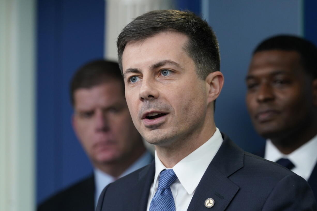 FILE - Transportation Secretary Pete Buttigieg, center, speaks during a briefing at the White House in Washington, May 16, 2022, as Labor Secretary Marty Walsh, left, and Environmental Protection Agency administrator Michael Regan, right, listen. The Biden administration is saying the U.S. economy would face a severe economic shock if senators don't pass legislation this week to avert a rail worker strike. Walsh and Buttigieg are meeting with Democratic senators Thursday, Dec. 1, to underscore that rail companies will begin shuttering operations well before a potential strike begins on Dec. 9.