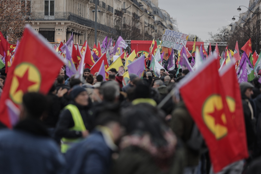 Kurdish activist and anti-racism group stage a protest against the recent shooting at the Kurdish culture center, holding Kurdistan Workers Party, PKK, flag in Paris, Saturday, Dec. 24, 2022.