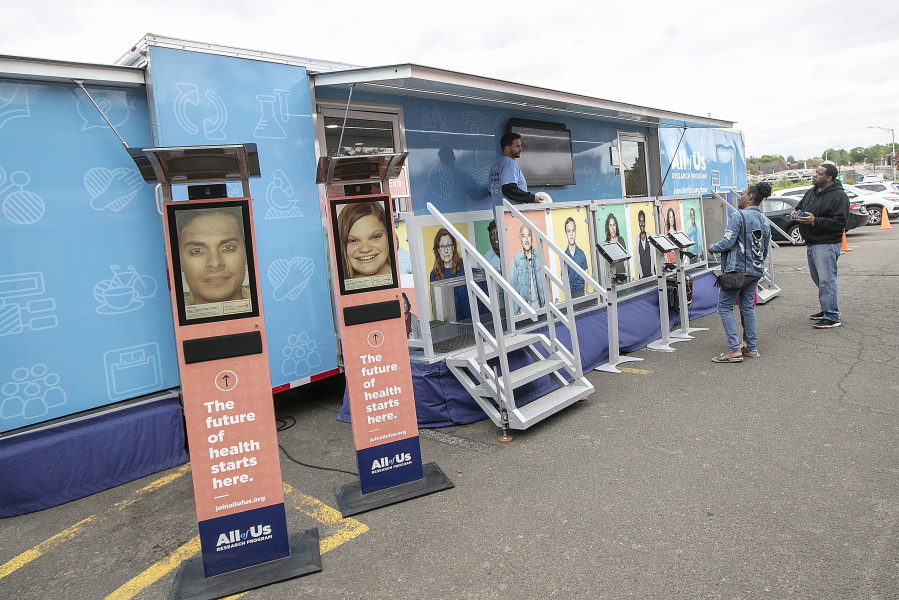FILE - People stand by the All of Us Mobile Education and Enrollment Center at the Community Health Center on State Street in Meriden, Conn., May 13, 2019. Thousands of Americans who shared their DNA for science are about to learn something in return: if they harbor some problematic genes. It's part of a massive National Institutes of Health project to unravel how people's genetics, environments and habits interact to mold their health.
