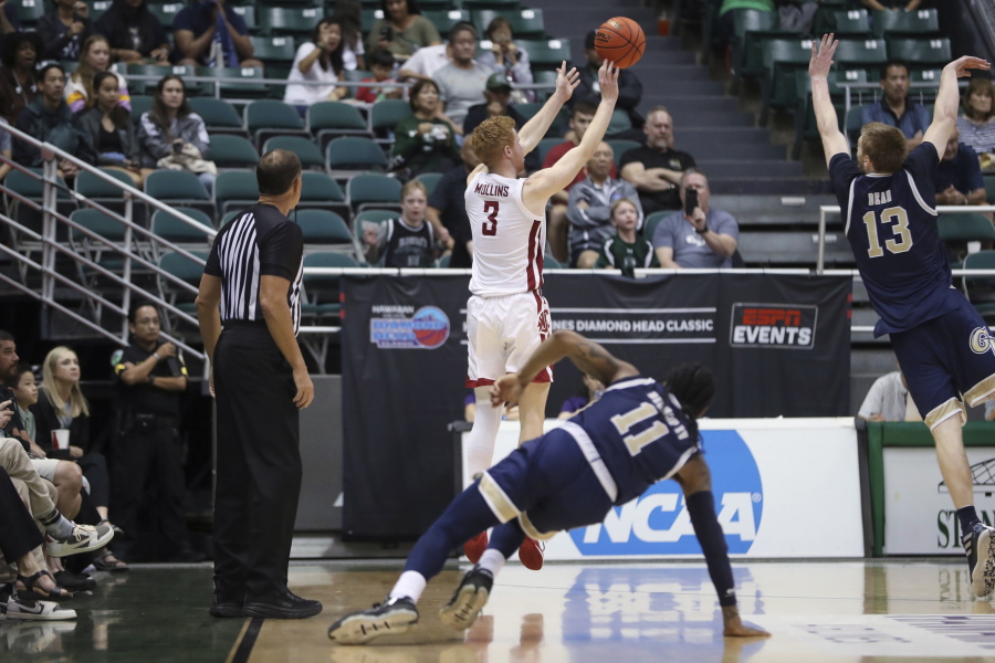 Washington State guard Jabe Mullins (3) makes a go-ahead 3-pointer in the closing seconds against George Washington in an NCAA college basketball game Thursday, Dec. 22, 2022, in Honolulu.