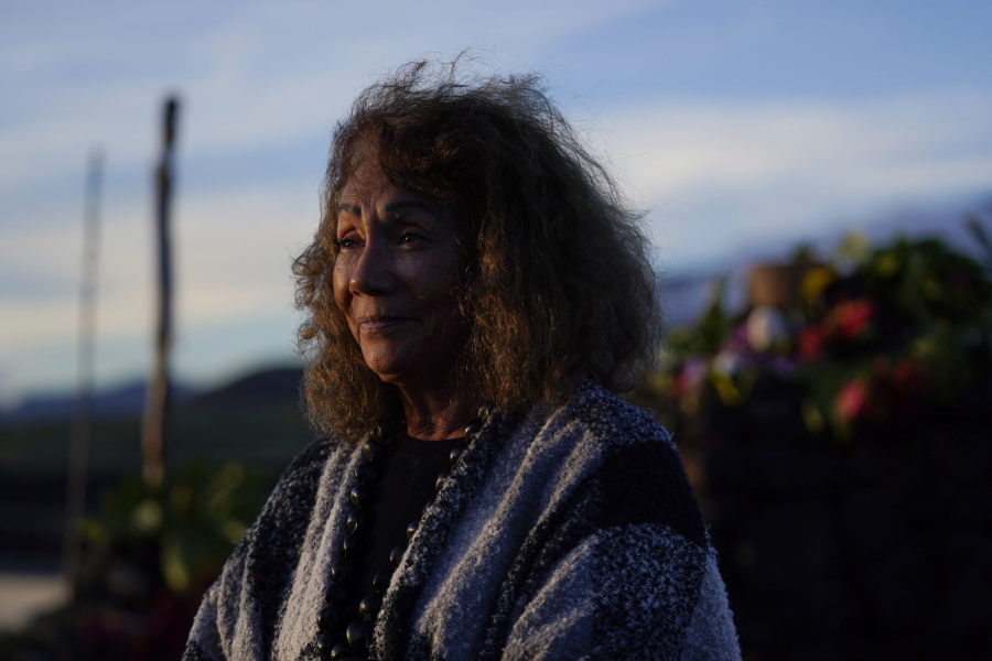 Illona Ilae, of Kailua-Kona, Hawaii, looks on after leaving an offering in front an alter below the Mauna Loa volcano as it erupts Thursday, Dec. 1, 2022, near Hilo, Hawaii. Glowing lava from the world's largest volcano is a sight to behold, but for many Native Hawaiians, Mauna Loa's eruption is a time to pray, make offerings and honor both the natural and spiritual worlds.