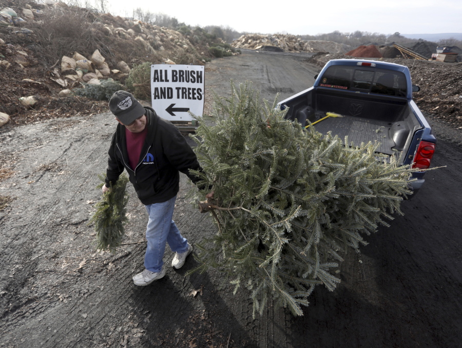 George Highhouse of Scranton, Pa., brings his Christmas tree and a wreath to Lackawanna County Recycling on Jan. 2, 2019, in Dunmore, Pa.