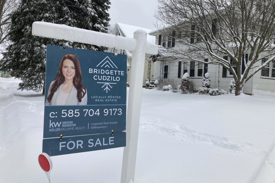 FILE - A "For Sale" sign stands in front of a house in Rochester, New York, on Monday, January 17, 2022. On Wednesday the National Association of Realtors reports on sales of existing homes in November.