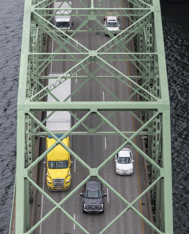 Cars and trucks travel north on the Interstate 5 Bridge, seen from the top of one of the northbound bridge lift towers.