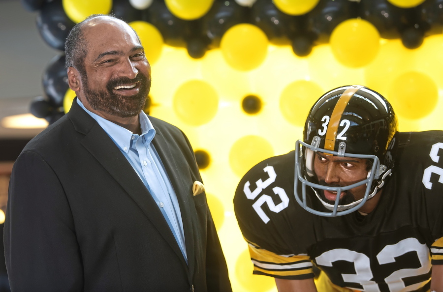 FILE - Former Pittsburgh Steelers running back Franco Harris stands next a statute of himself on Sept. 12, 2019, at Pittsburgh International Airport near Pittsburgh.