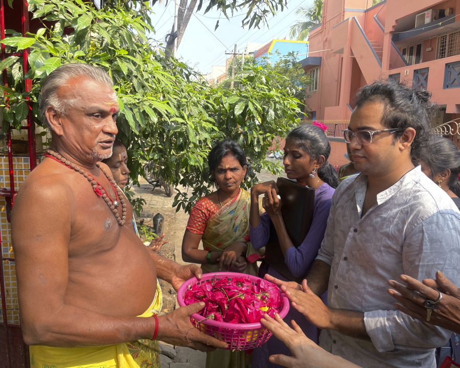 Arjun Viswanathan places his hands on a basket of flowers to be offered to the Hindu deity Ganesh at the Sri Lakshmi Visa Ganapathy Temple on Nov. 28 in Chennai, a city on the southern coast of India.