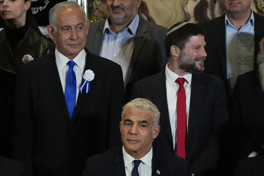 FILE-Israeli Prime Minister Yair Lapid, center, Likud Party leader Benjamin Netanyahu, left, far-right Israeli lawmaker Bezalel Smotrich and leaders of all Israel's political parties pose for a group photo after the swearing-in ceremony for Israeli lawmakers at the Knesset, Israel's parliament, in Jerusalem, Tuesday, Nov. 15, 2022. Israel's designated prime minister, Benjamin Netanyahu, has announced a coalition deal with a hardline pro-settler party on Thursday, Dec. 1, 2022. The agreement will give Religious Zionism control over a number of key government ministries and a senior post over West Bank settlement construction.