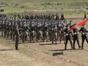 FILE - In this photo released by the Russian Defense Ministry Press Service, Chinese troops line up (march) during the Vostok 2022 military exercise at a firing range in Russia's Far East, on Aug. 31, 2022. A Japanese government-commissioned panel said in a report to Prime Minister Fumio Kishida, that drastic defense buildup including possession of pre-emptive strike capability is "indispensable" amid growing threats in the region, calling for the public's understanding to bear the financial burden for the defense of their country.
