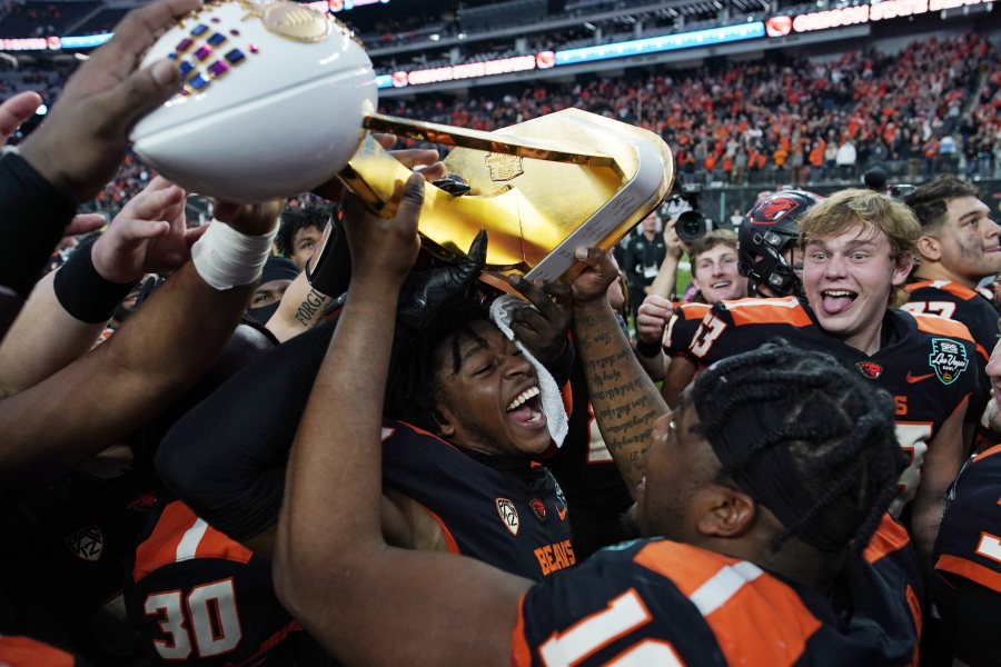 Oregon State players celebrate with the trophy after defeating Florida in the Las Vegas Bowl NCAA college football game Saturday, Dec. 17, 2022, in Las Vegas.