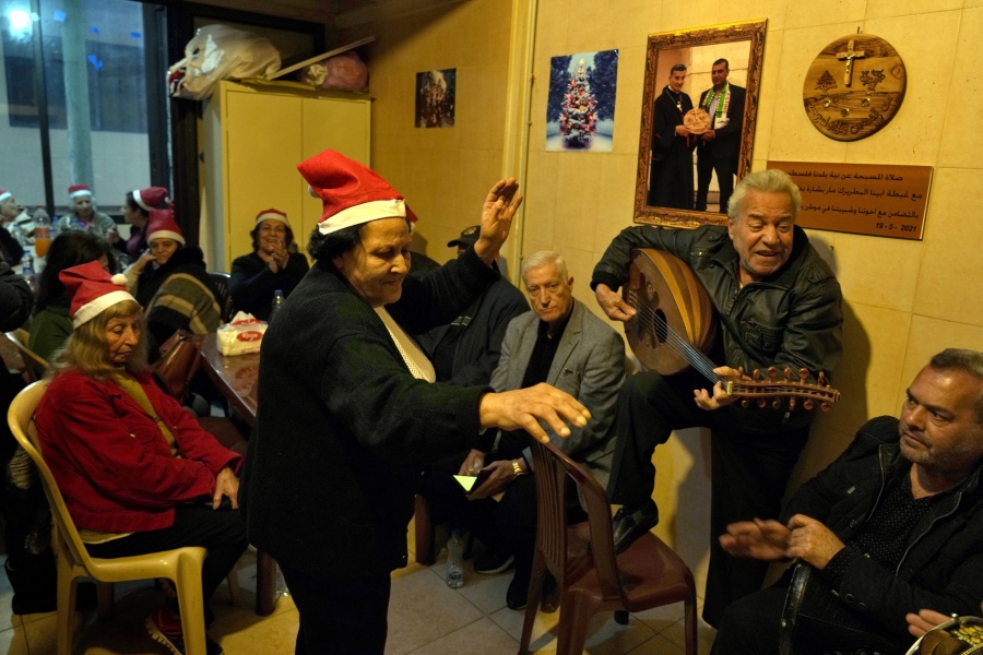 Amira Mansour, center, dances as Samir Damouni playing the Oud during community Christmas dinner for elderly residents at the only majority-Christian Palestinian refugee camp, in Dbayeh, north of Beirut, Lebanon, Wednesday, Dec. 21, 2022. Hundreds of thousands of Palestinians fled or were forced from their homes during the 1948 Mideast war over Israel's creation. Today, several million Palestinian refugees and their descendants are scattered across Jordan, Syria and Lebanon, as well as the West Bank and Gaza, lands Israel captured in 1967.