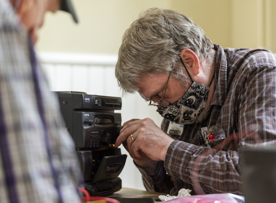 Repair Clark County volunteer Ken Olsen examines the tape deck of a stereo at an event last June. The free repair program returns beginning in January.