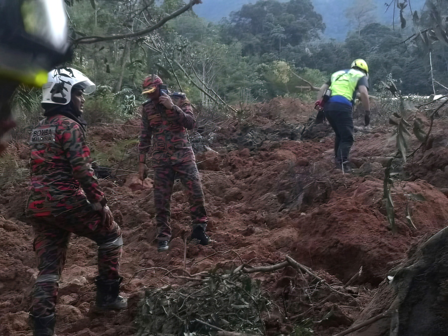 In this photo released by Korporat JBPM, rescuers work during a rescue and evacuation operation following a landslide at a campsite in Batang Kali, Selangor state, on the outskirts of Kuala Lumpur, Malaysia, Dec. 16, 2022.